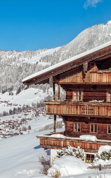 Auf dem Bild zu sehen ist die verschneite Winterlandschaft in Alpbach, im Vordergrund ein altes Bauernhaus