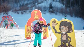 Ein Mädchen fährt mit ihren Skiern durch kleine Bögen von der Skischule 