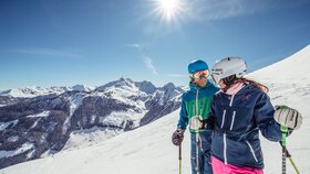 Ein Paar steht auf der Skipiste in Alpbach und genießt die schöne Winterlandschaft  | © Alpbachtal Tourismus | shootandstyle