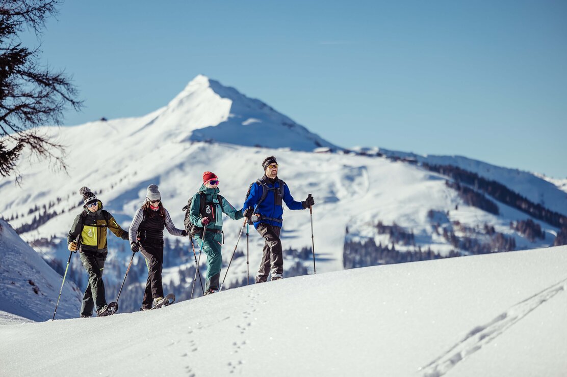 Schneeschuhwanderung in Alpbach | © Alpbachtal Tourismus | shootandstyle Vier Personen, wandern mit ihren Schneeschuhen durch die verschneite Winterlandschaft, im Hintergrund die Berge  | © Alpbachtal Tourismus | shootandstyle