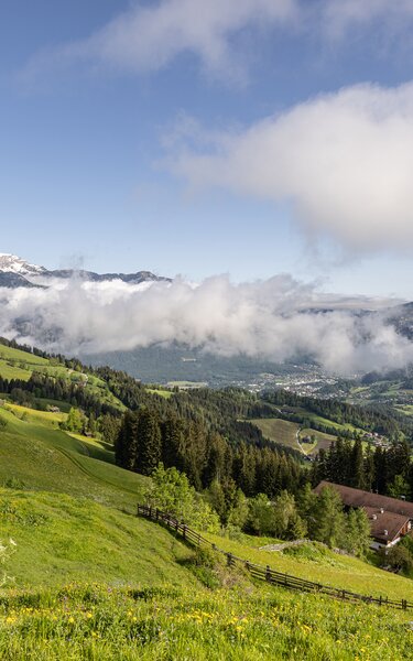 Auf dem Bild sieht man hinunter auf ein Haus mit Zaun und dahinter das Alpbachtal. | © Alpbachtal Tourismus