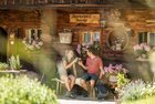 Jausenstation Thalerhof Alpbach | © Alpbachtal Tourismus | shootandstyle Ein paar gießt gerade ihr Bier im Garten der Jausenstation Thalerhof, im Garten blühen viele Blumen und Sträucher | © Alpbachtal Tourismus | shootandstyle