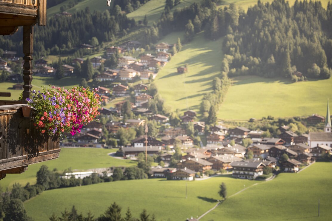 Ausblick auf Alpbach, im Vordergrund ein Holzbalkon mit wunderschönen Blumen  | © Alpbachtal Tourismus | shootandstyle 