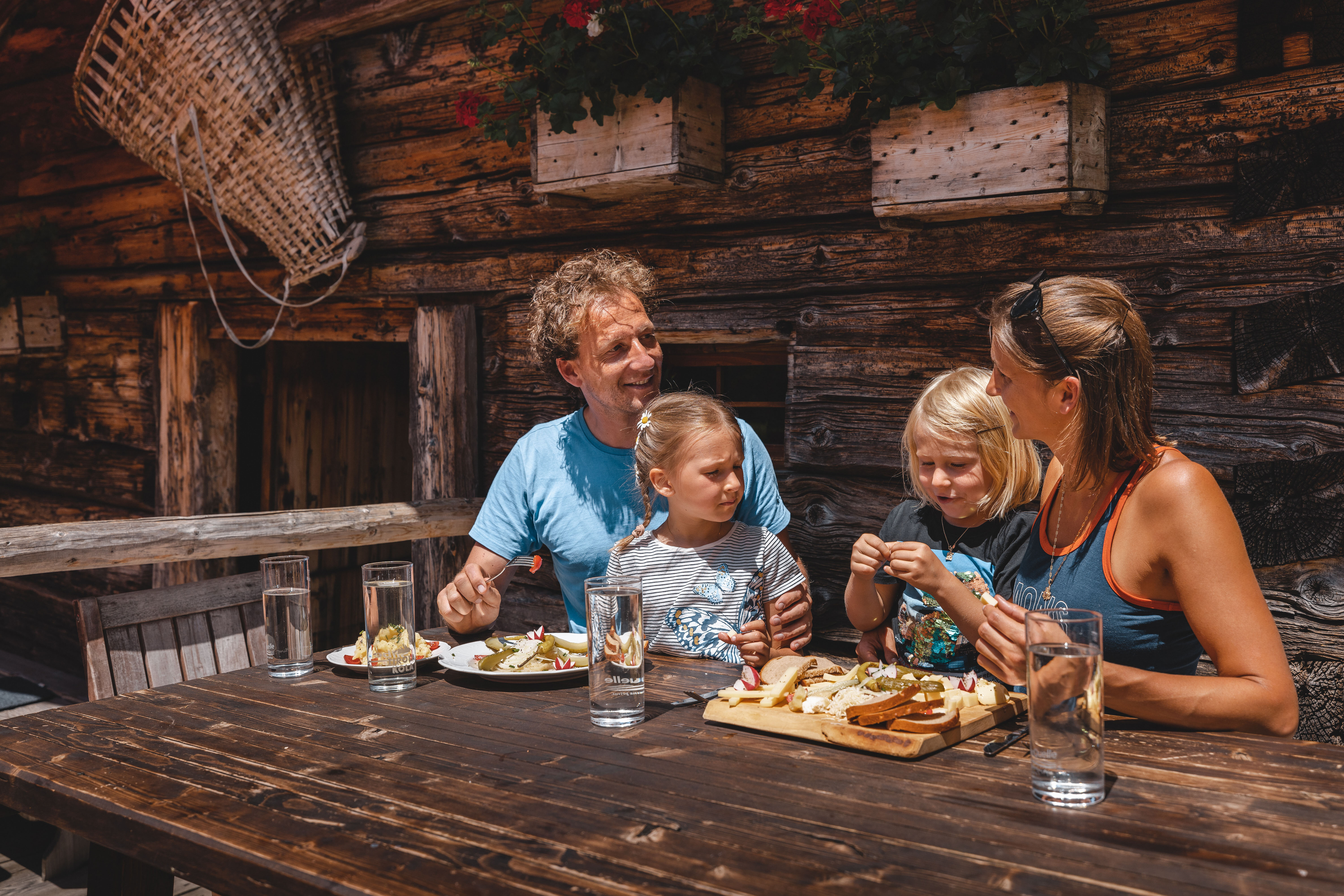 Eine Familie genießt die Brettljause auf der Farmkehralm  | © Alpbachtal Tourismus | Mathäus Gartner 