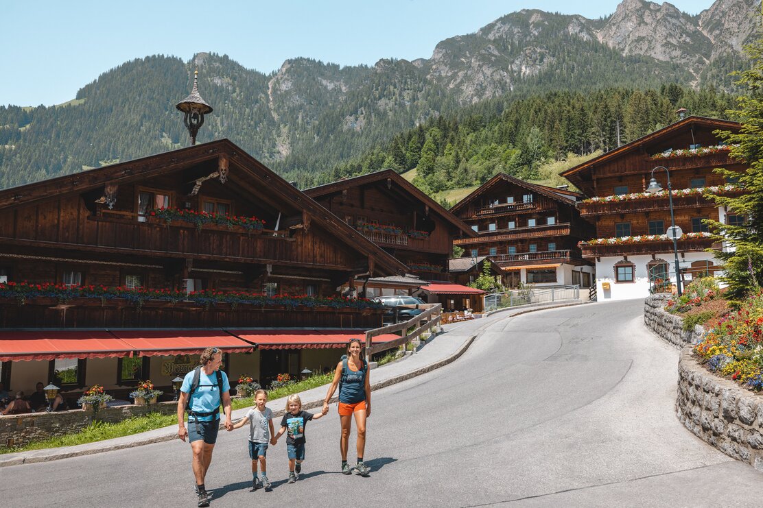 Eine Familie spaziert Hand in Hand durch das Dorfzentrum in Alpbach  | © Alpbachtal Tourismus | Matthäus Gartner 