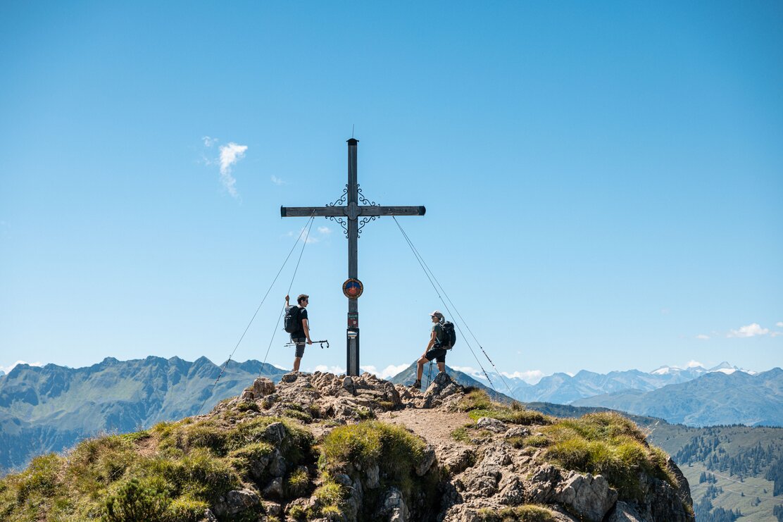Ein Paar genießt gemeinsam den Gipfelsieg am Gipfelkreuz Gratlspitze im Alpbachtal  | © Alpbachtal Tourismus | shootandstyle 