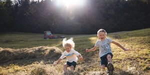Spielespaß in Reith i.A. | © Alpbachtal Tourismus | Mathäus Gartner Zwei Kinder (ein Mädchen und ein Junge) springen im Heuhaufen hin und her | © Alpbachtal Tourismus | Mathäus Gartner