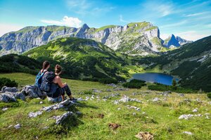 Zwei Frauen sitzen auf kleine Felsen und blicken auf den wunderschönen Bergsee, dem Zireiner See im Rofangebirge  | © Alpbachtal Tourismus