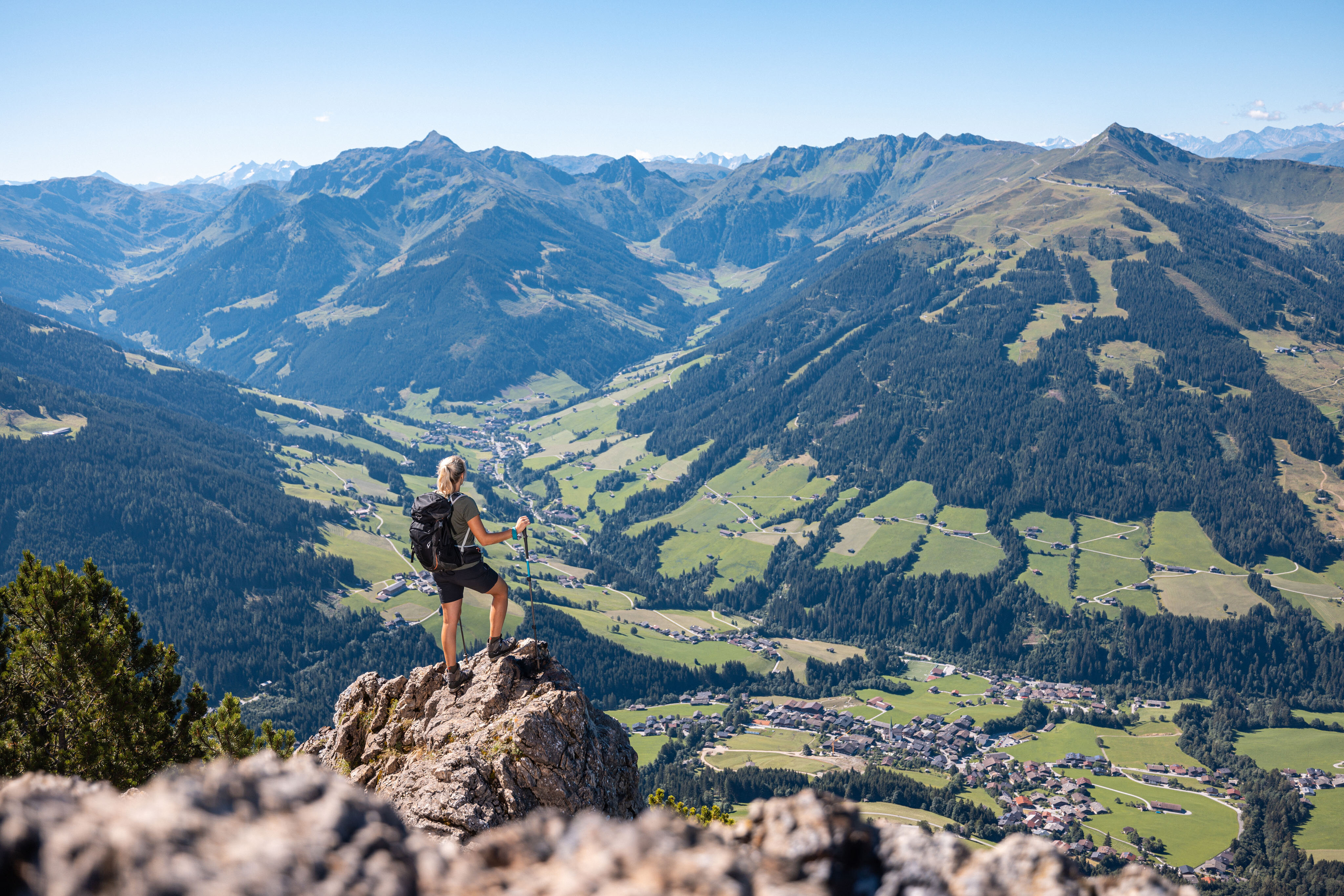 Eine Frau steht auf einem Fels auf dem Gipfel Gratlspitze und betrachtet die schöne Aussicht auf das Alpbachtal  | © Alpbachtal Tourismus | shootandstyle 
