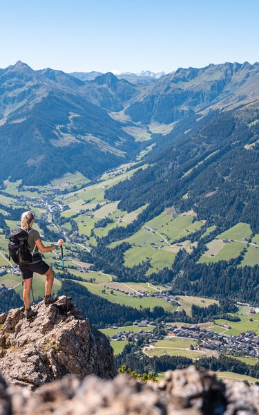 Eine Frau steht auf einem Fels auf dem Gipfel Gratlspitze und betrachtet die schöne Aussicht auf das Alpbachtal  | © Alpbachtal Tourismus | shootandstyle 