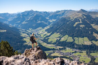 Eine Frau steht auf einem Fels auf dem Gipfel Gratlspitze und betrachtet die schöne Aussicht auf das Alpbachtal  | © Alpbachtal Tourismus | shootandstyle 