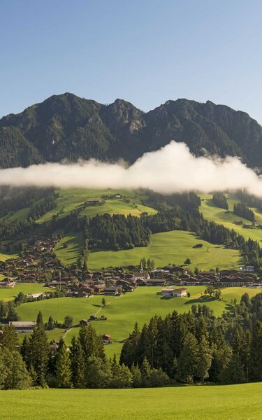 Blick auf das Dorf Alpbach, mit schönen Häusern und umgeben von einer grünen Naturlandschaft | © Alpbachtal Tourismus | Shootandstyle
