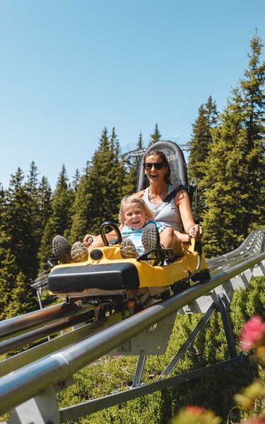 Lauser Sauser Alpbach | © Alpbachtal Tourismus | Mathäus Gartner Mutter fährt gemeinsam mit ihrem Sohn eine Runde mit dem Alpine Coaster Lauser Sauser in Alpbach | © Alpbachtal Tourismus | Mathäus Gartner