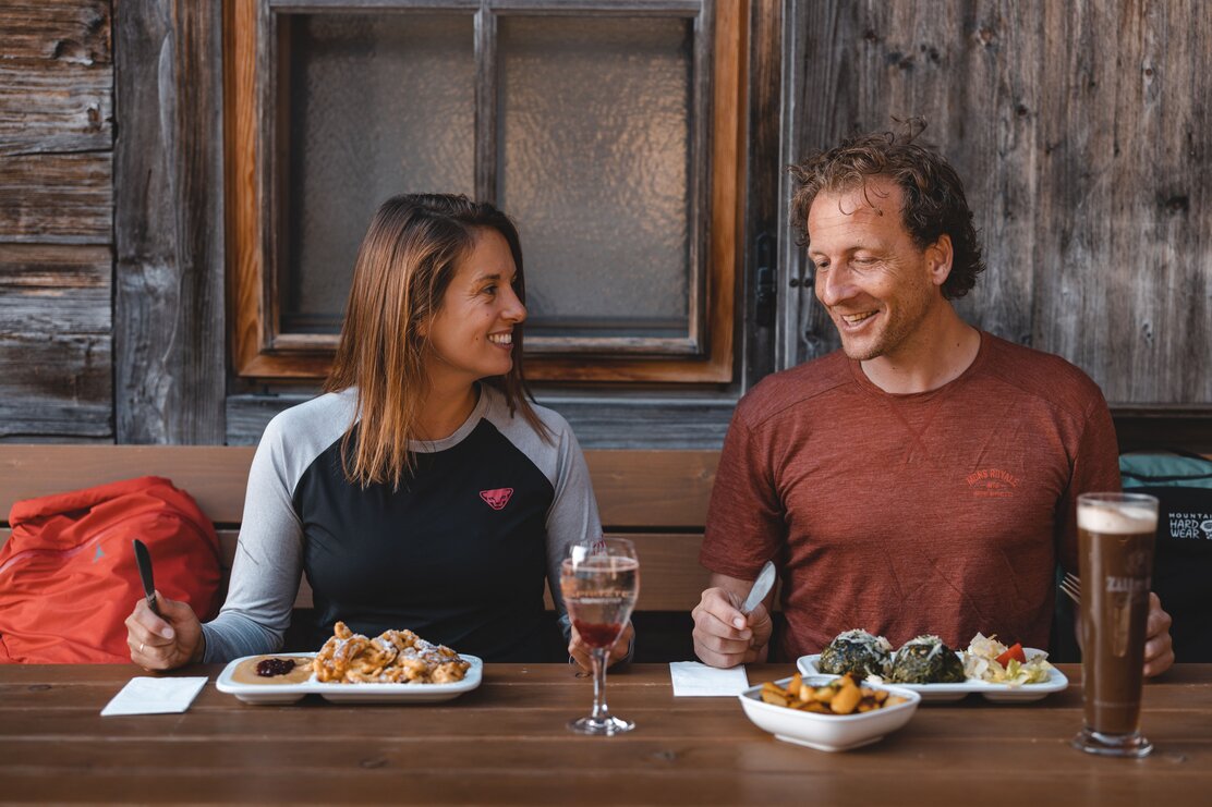 Ein Paar isst genüsslich ihr Essen auf der Holzalm in Brixlegg  | © Alpbachtal Tourismus | Mathäus Gartner 
