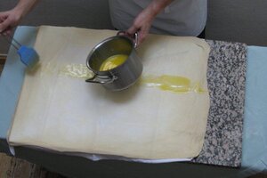 Chef Konditor Reinhard Hacker bei der Arbeit (er bestreicht den Teig mit Butter für die Strudelfüllung), im Familienbetrieb Café Konditorei Hacker in Rattenberg | © Alpbachtal Tourismus