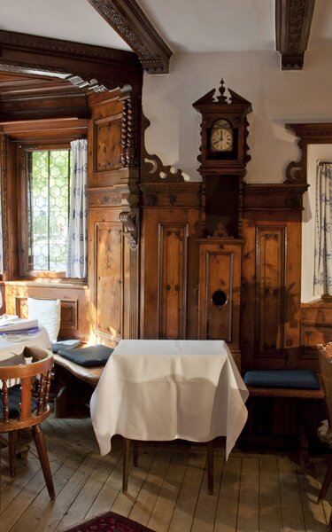 Auf dem Bild zu sehen ist eine rustikale Gaststube mit zwei voll eingedeckten Tischen | © Alpbachtal Tourismus 