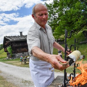 Man sieht Herrn Mader beim Prügeltorte backen im Höfemuseum. | © Alpbachtal Tourismus