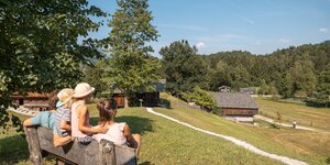 Familienausflug Museum Tiroler Bauernhöfe in Kramsach | © Alpbachtal Tourismus | shootandstyle Eine Familie sitzt auf einer Bank im Museum Tiroler Bauernhöfe in Kramsach | © Alpbachtal Tourismus | shootandstyle