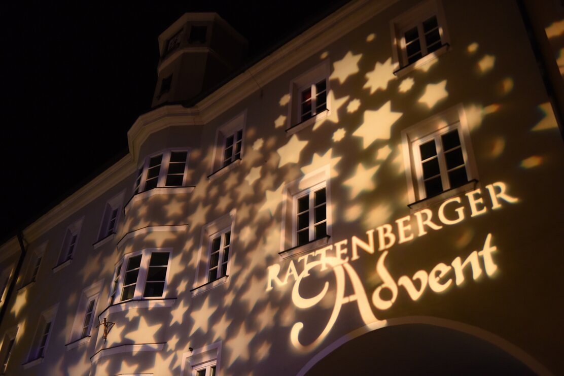 Das Logo des Rattenberger Advents wird mit einem Projektor an die Wand projiziert, rundherum viele Sterne | © Alpbachtal Tourismus 