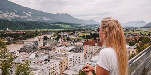 Ausblick auf die Stadt Rattenberg | © Good Morning World | Janina Zasche Eine Frau befindet sich auf der Burgruine Schlossberg und genießt die Aussicht auf die kleine Stadt Rattenberg mit ihren bunten Häusern | © Good Morning World | Janina Zasche
