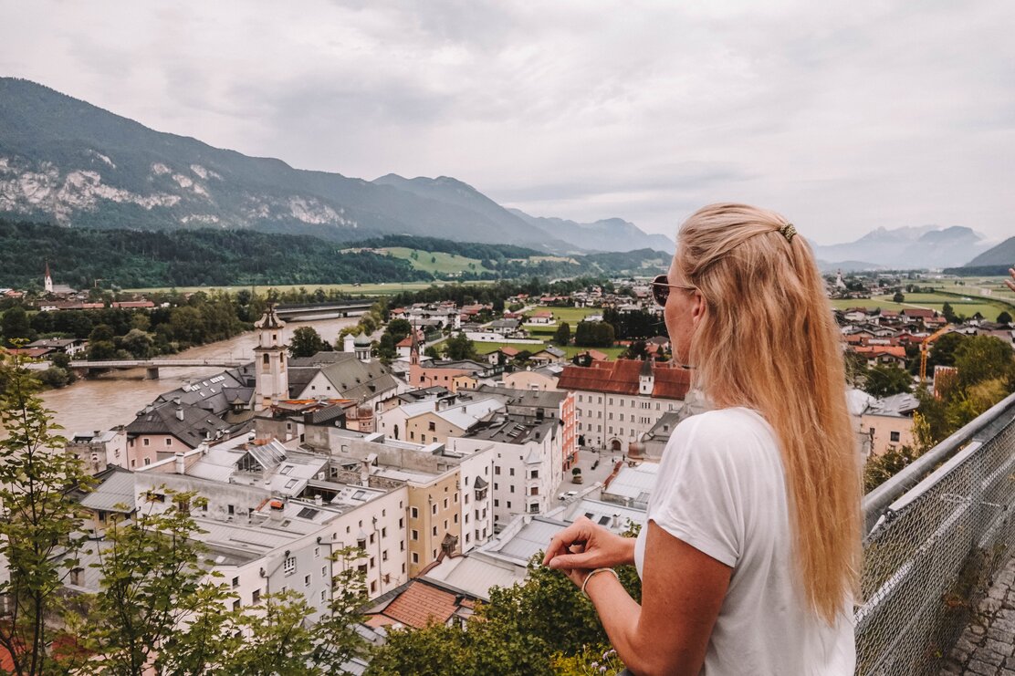 Eine Frau befindet sich auf der Burgruine Schlossberg und genießt die Aussicht auf die kleine Stadt Rattenberg mit ihren bunten Häusern | © Good Morning World | Janina Zasche 