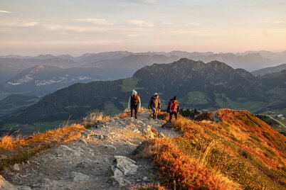 Zwei Männer und eine Frau wandern gerade zum Gipfel  Wiedersberger Horn, im Hintergrund die schöne Aussicht auf das Alpbachtal  | © Alpbachtal Tourismus | shootandstyle 