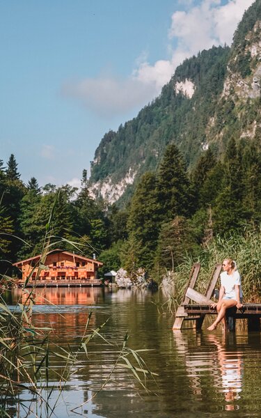 Naturjuwel Berglsteinersee | © Good Morning World | Janina Zasche Eine Frau entspannt in der Natur am Steg des Berglsteinersees | © Good Morning World | Janina Zasche