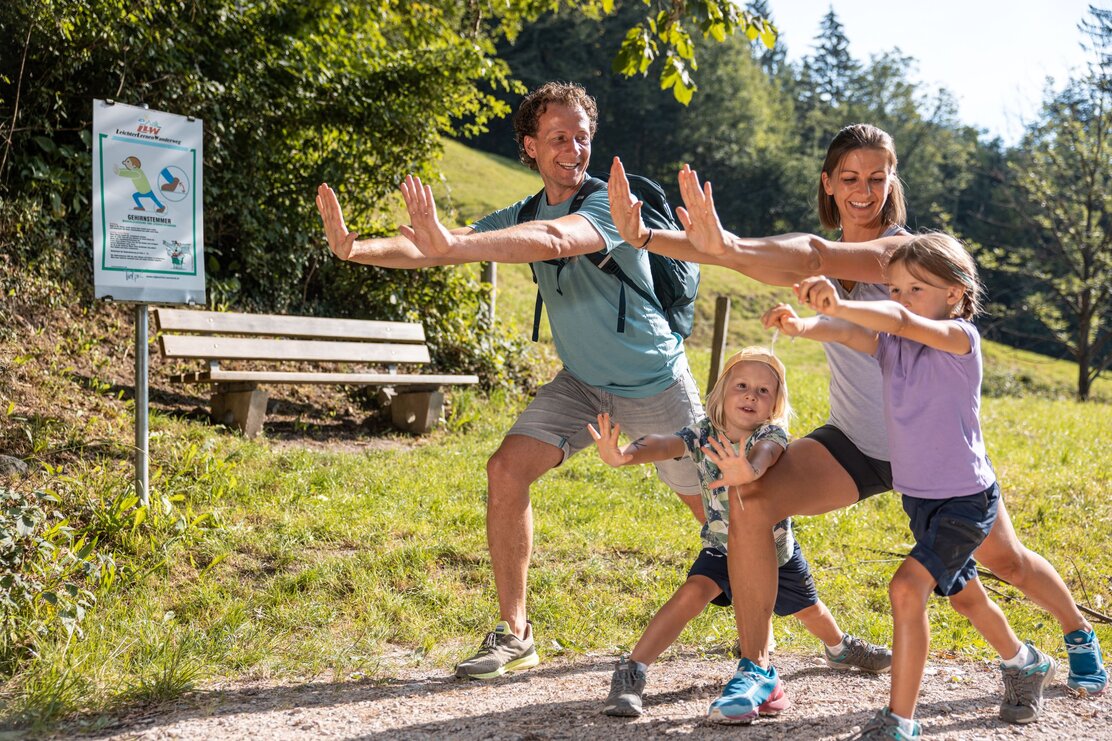 Eine Familie macht gemeinsam eine Übung der Fitnessstation auf dem Weg zum Berglsteinersee  | © Alpbachtal Tourismus | shootandstyle 