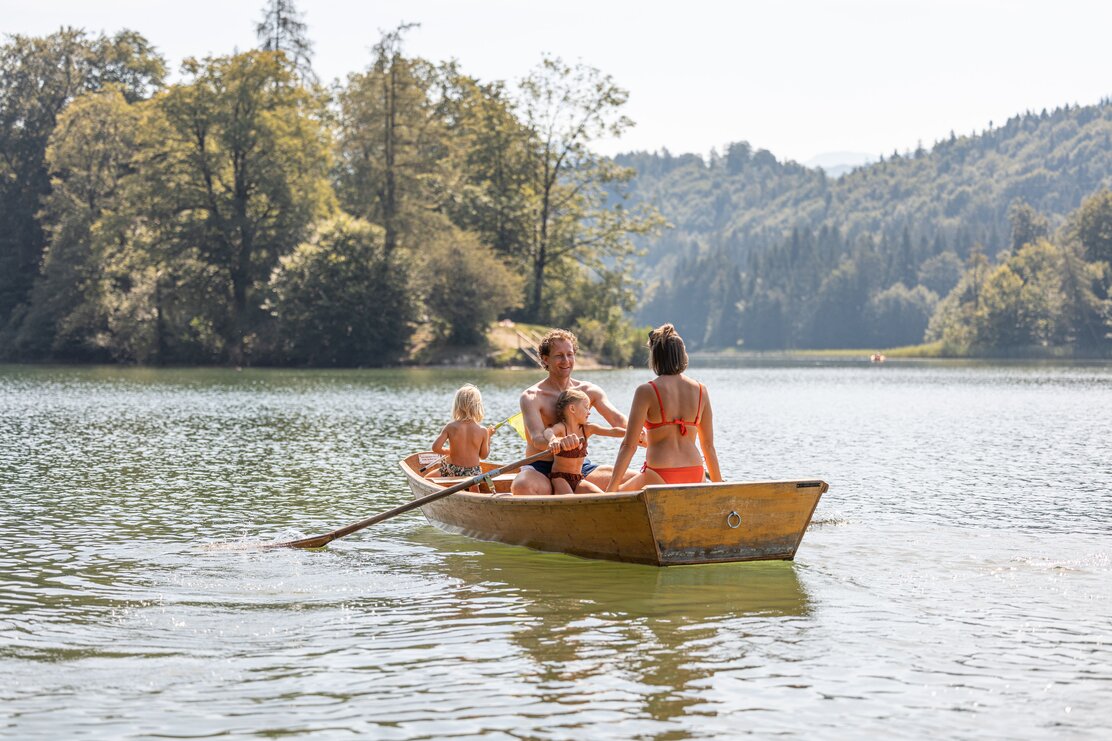 Eine Familie sitzt gemeinsam in einem Paddelboot am Reintalersee in Kramsach  | © Alpbachtal Tourismus | shootandstyle 