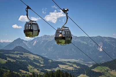 Auf diesem Bild zu sehen sind zwei Gondeln der Wiedersbergerhornbahn, im Hintergrund der Blick aufs Tal  | © Alpbachtal Tourismus | Gabriele Grießenböck 