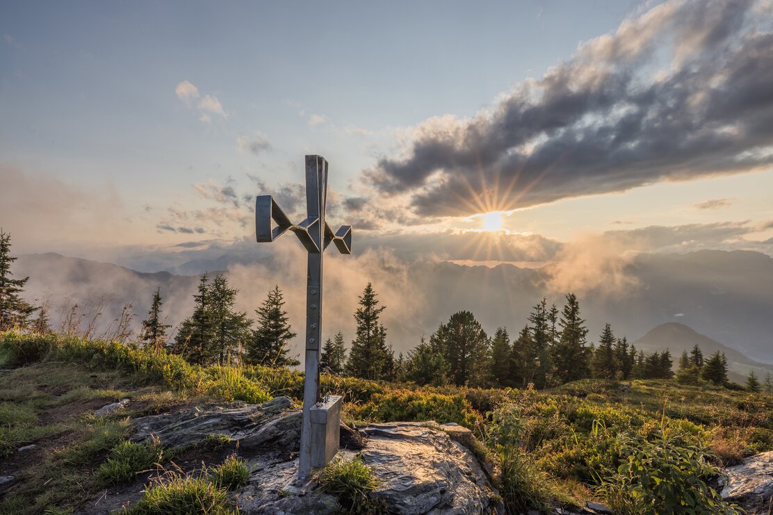 Gipfelkreuz Loderstein in Reith i.A., im Hintergrund eine schöne Bergkulisse mit Sonnenuntergang  | © Alpbachtal Tourismus | shootandstyle 