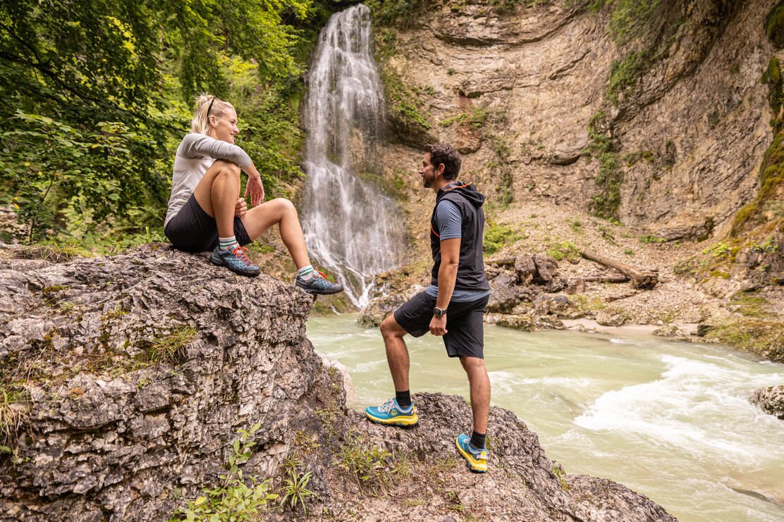 Ein fröhliches Paar genießt die Stunden auf einem großen Stein an der Tiefenbachklamm. | © Alpbachtal Tourismus | shootandstyle