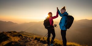 Sonnenaufgangsfahrt Wiedersberger Horn | © Alpbachtal Tourismus | shootandstyle Zwei Freundinnen klatschen vor Freude in die Hände und genießen den Sonnenaufgang am Berg | © Alpbachtal Tourismus | shootandstyle