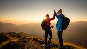 Zwei Freundinnen klatschen vor Freude in die Hände und genießen den Sonnenaufgang am Berg | © Alpbachtal Tourismus | shootandstyle 