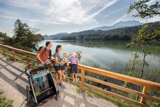 Eine Familie spaziert mit ihren Kindern samt Kinderwagen, den barrierefreien Wanderweg am Reintalersee entlang  | © Alpbachtal Tourismus | shootandstyle 