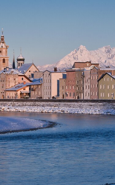 Zu sehen ist die kleine verschneite Stadt Rattenberg, mit ihren alten bunten Häusern, im Hintergrund ragen große verschneite Gipfel hervor  | © Alpbachtal Tourismus 