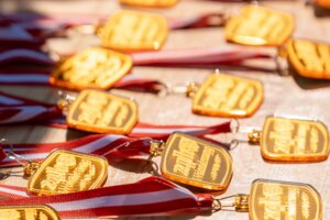 Auf diesem Bild zu sehen sind die goldenen Medaillen, der 24h Wanderung, welche die Teilnehmer am Ende der Wanderung bekommen  | © Alpbachtal Tourismus | shootandstyle 