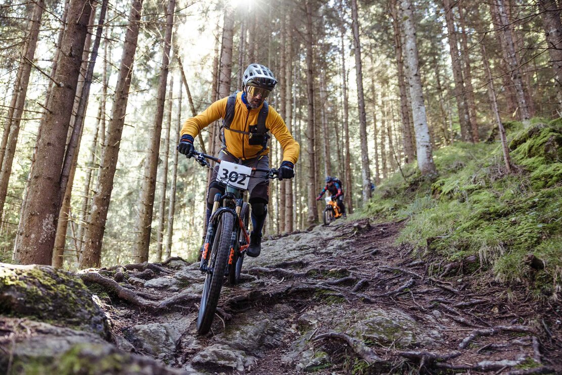 Die Startnummer 302, flitzt Vollgas bergab, über viele Wurzeln in Richtung Tal bergab | © Alpbachtal Tourismus | shootandstyle 