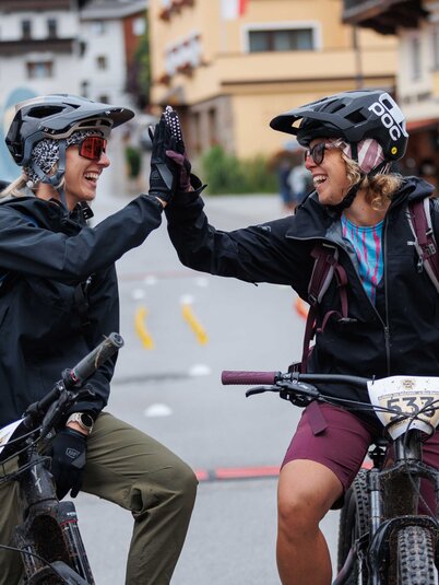 Zwei Frauen, geben sich nachdem sie am Ziel angekommen sind, ein High 5, beim E-Bike Battle in Reith i.A.  | © Alpbachtal Tourismus | Maximalgrafik 