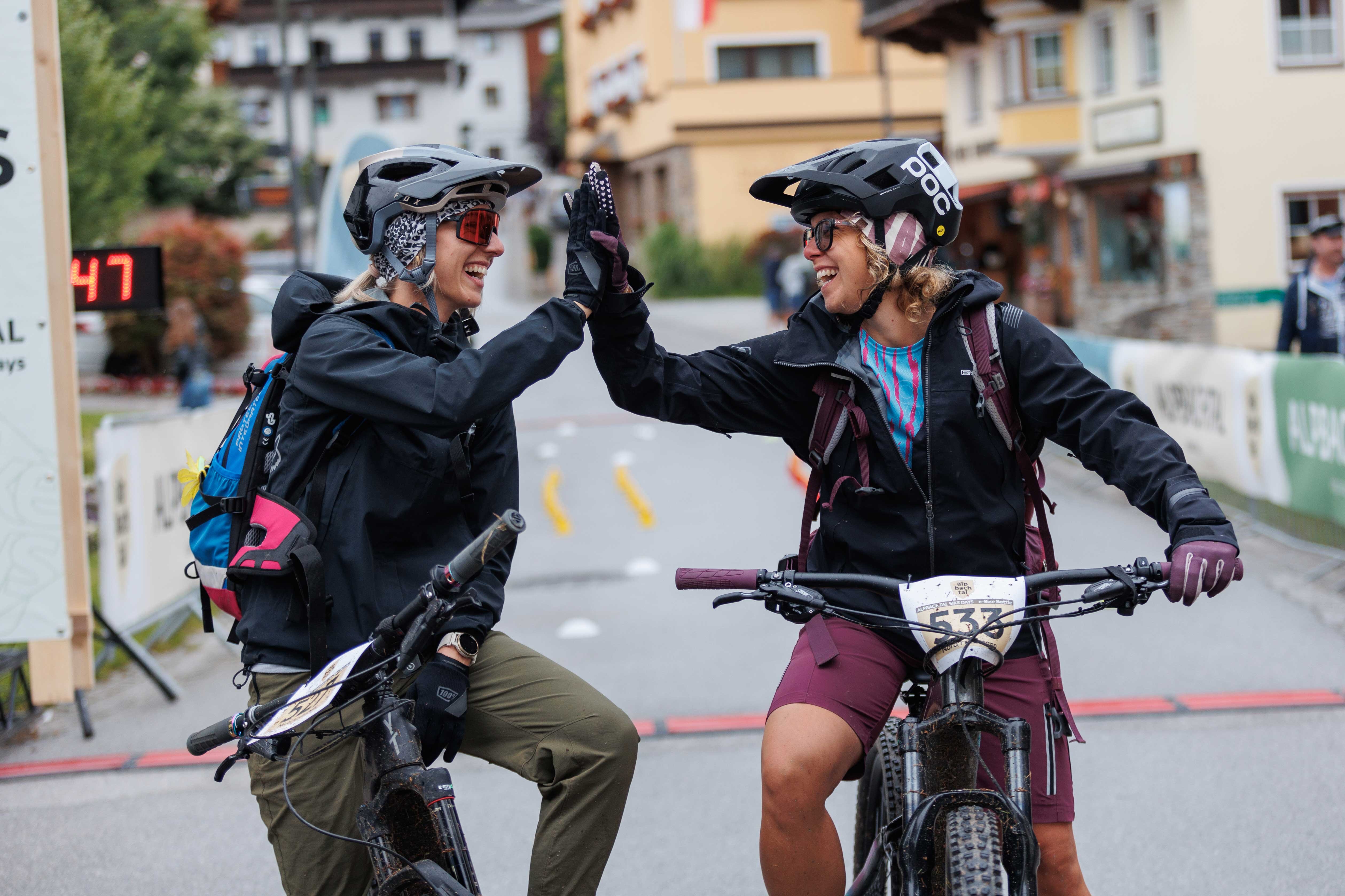 Zwei Frauen, geben sich nachdem sie am Ziel angekommen sind, ein High 5, beim E-Bike Battle in Reith i.A.  | © Alpbachtal Tourismus | Maximalgrafik 