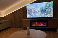 Wohnzimmer mit TV und Elektrokamin