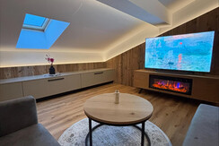 Gemütliches Wohnzimmer mit TV und Elektrokamin