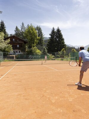 Foto Tennisplatz mit Spieler und Galtenberg