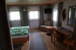 Doppelzimmer mit Sitzmöglichkeiten und TV